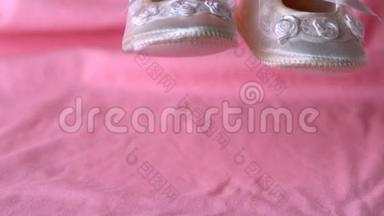 婴儿鞋落在粉红色的毯子上